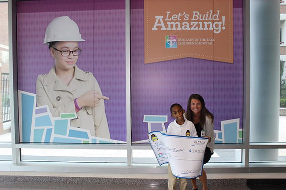 Leroy III giving his first check to "Our Lady Of The Lake Children's Hospital, Baton Rouge