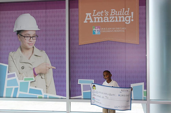 Leroy III giving his first check to "Our Lady Of The Lake Children's Hospital, Baton Rouge