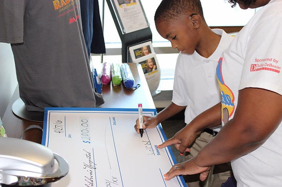 Leroy III signing his first check to "Our Lady Of The Lake Children's Hospital, Baton Rouge